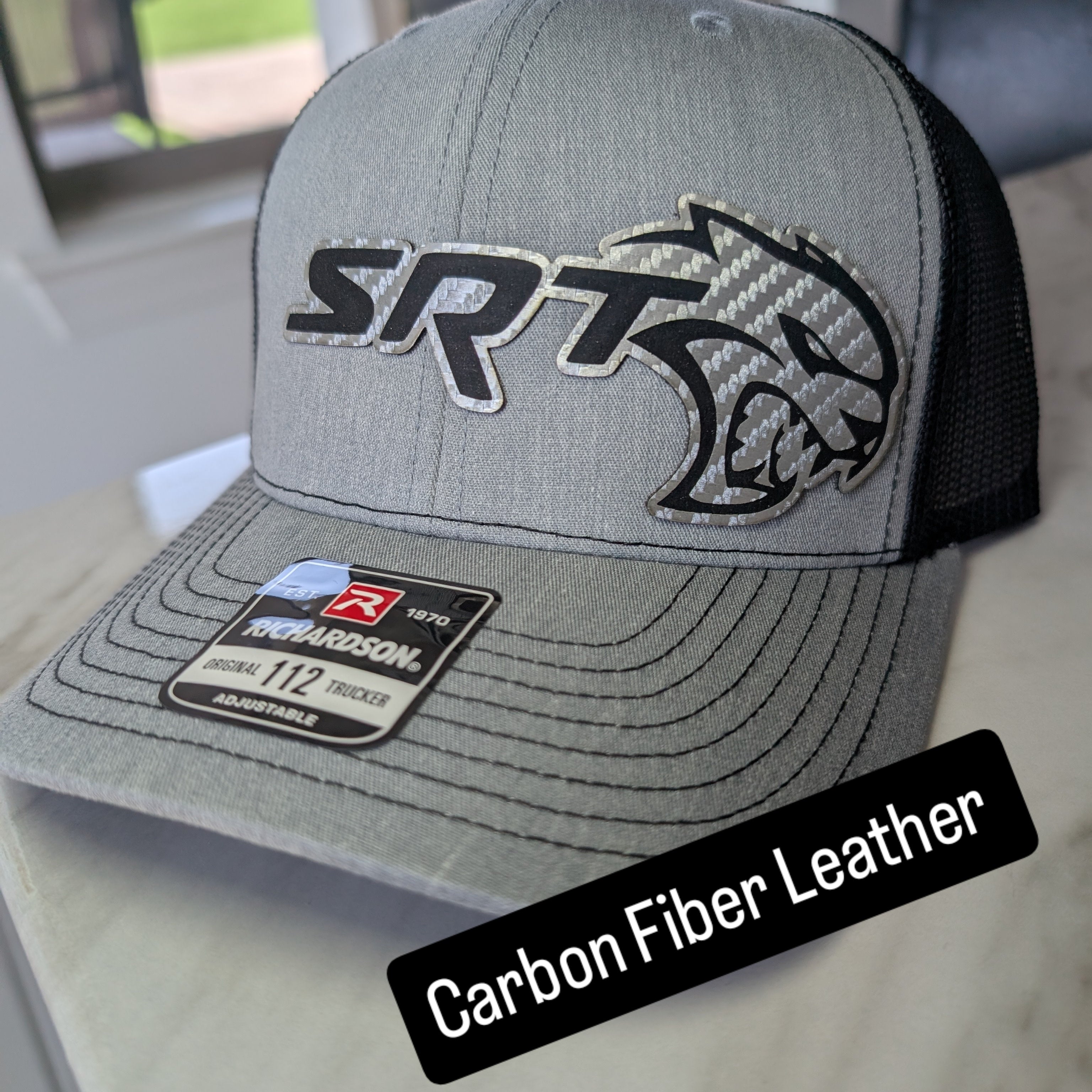 Hellcat Inspired Laser Engraved Richardson 112 Hat with Silver Carbon Fiber, Red Leather, and Gold Leather Accents." That should give all the details you need!